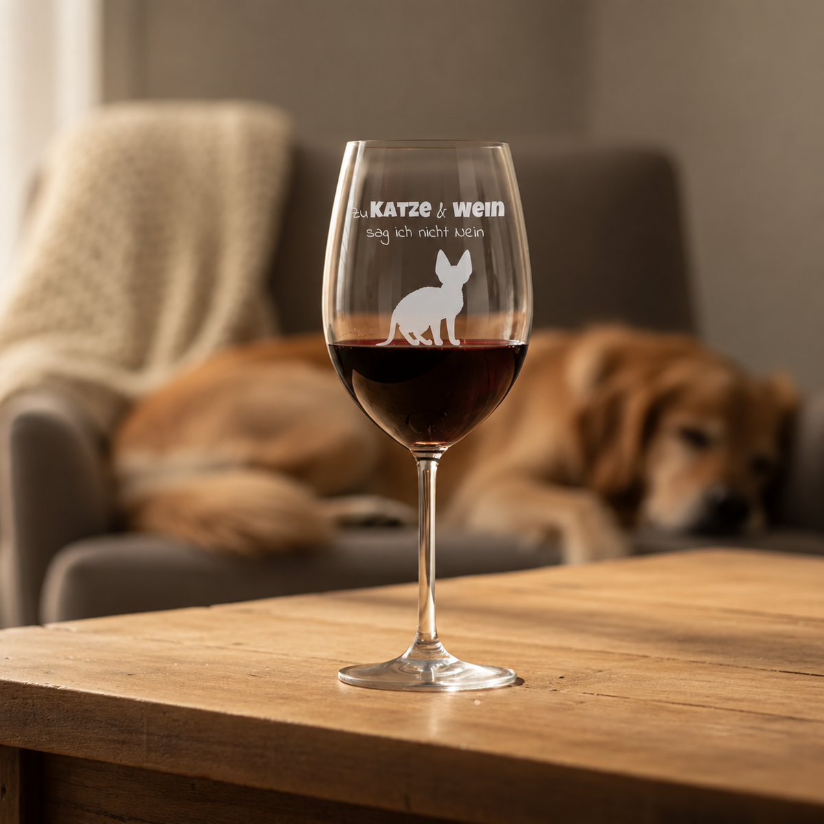 Copa de vino personalizada con frase grabada y gato, llena de vino tinto sobre una mesa de madera.