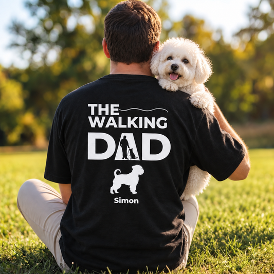 Camiseta negra con el texto "The Walking Dad" y un motivo de perro, llevada por una persona al aire libre.