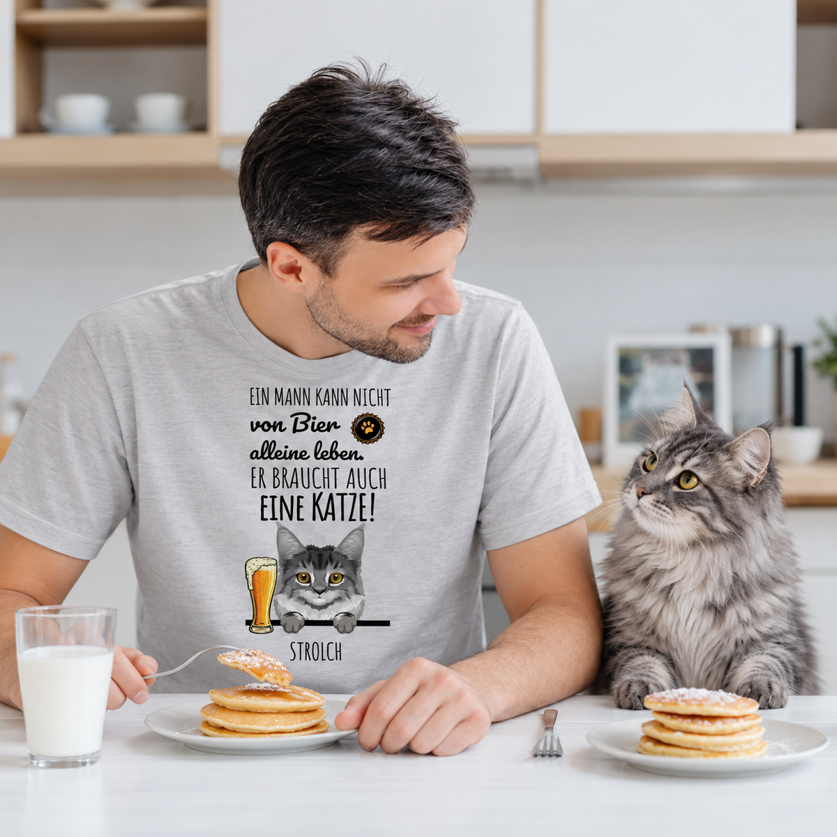 Camiseta gris personalizada con divertido diseño de gato y frase sobre cerveza, llevada por un hombre en una mesa.