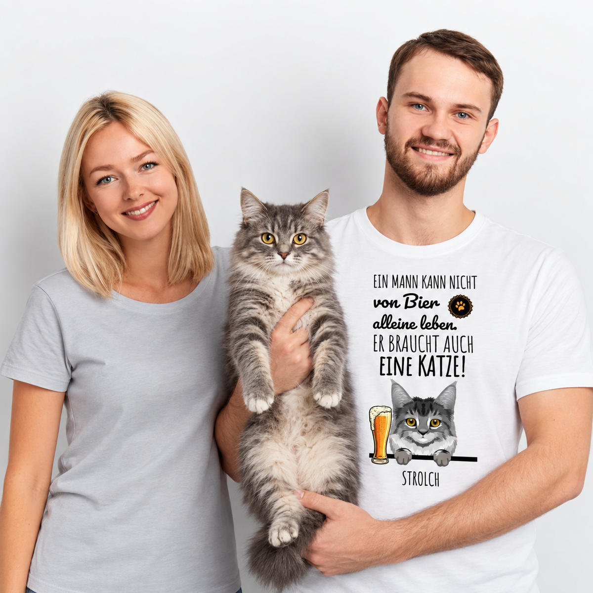 Camiseta blanca personalizada con motivo de gato y frase. Él sostiene un gato, a su lado una mujer.