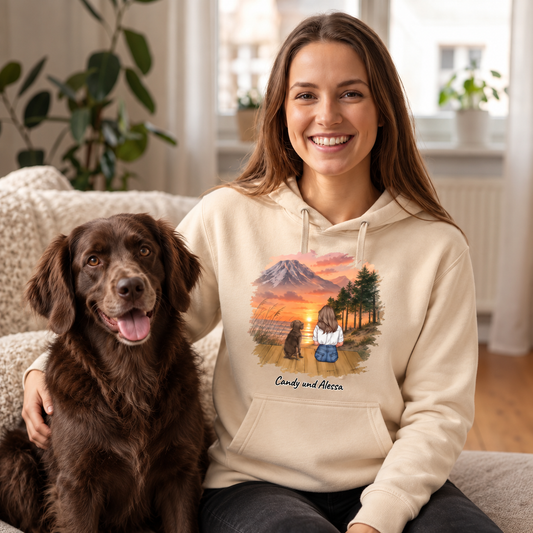Sudadera con capucha beige con motivo personalizado de una mujer y su perro ante un paisaje de montaña.