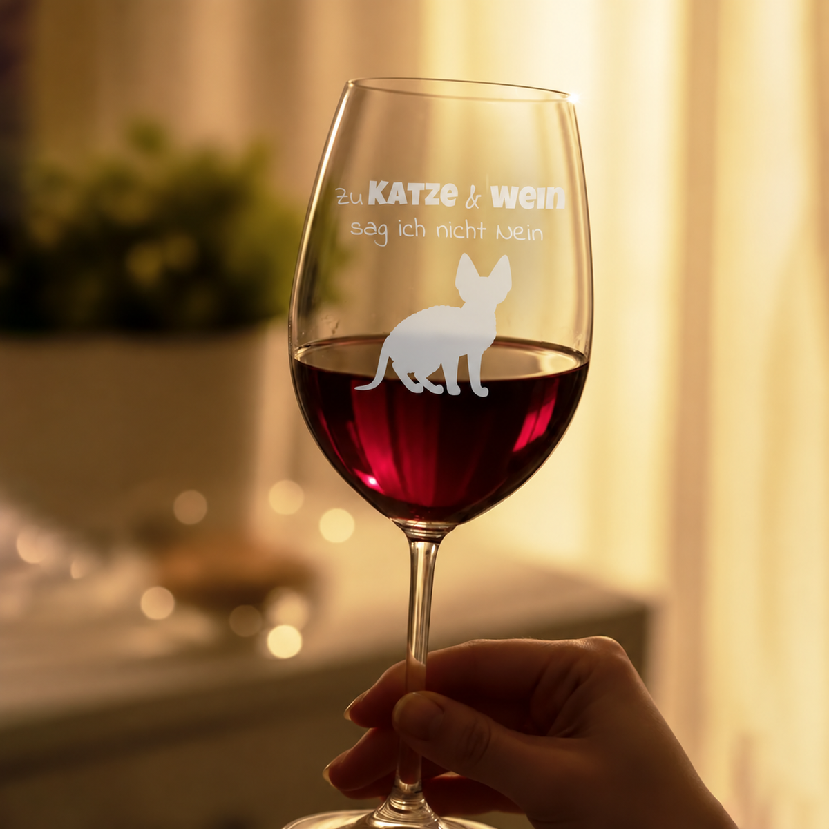 Copa de vino personalizada con inscripción grabada y motivo de gato, llena de vino tinto.