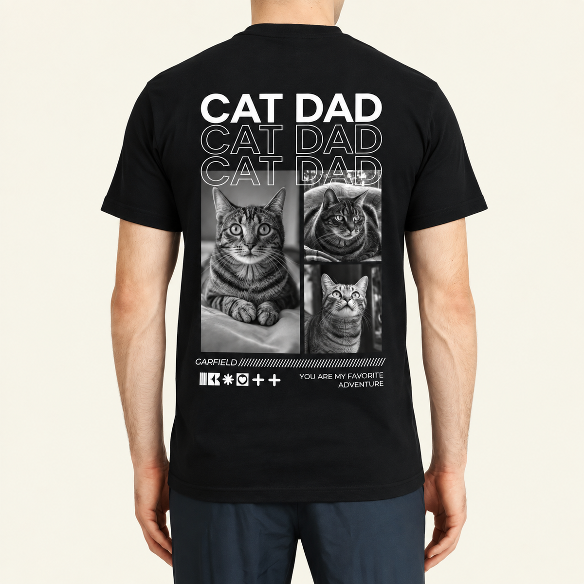 Camiseta negra con el texto "Cat Dad" y fotos de gatos en la espalda.