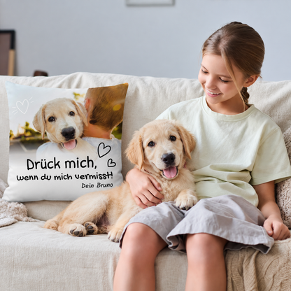 Cojín beige personalizado con impresión y foto de perro, en un sofá con una niña y un perro.