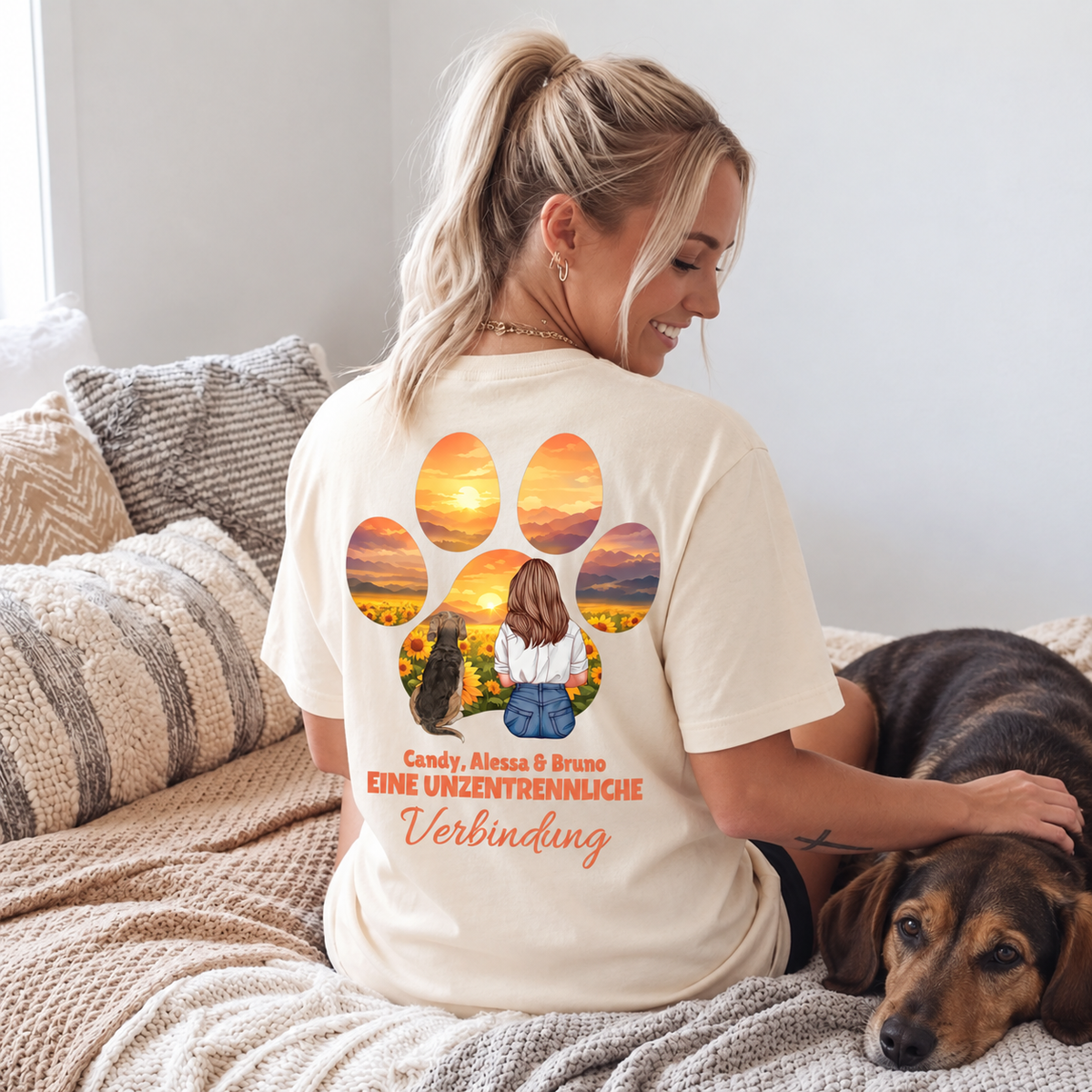 Camiseta beige con impresión gráfica de una niña y un perro, rodeados de atardecer y flores.