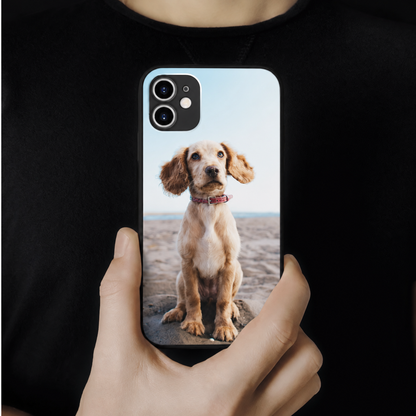 Funda de móvil personalizada con una foto de un perro, sostenida por una persona.