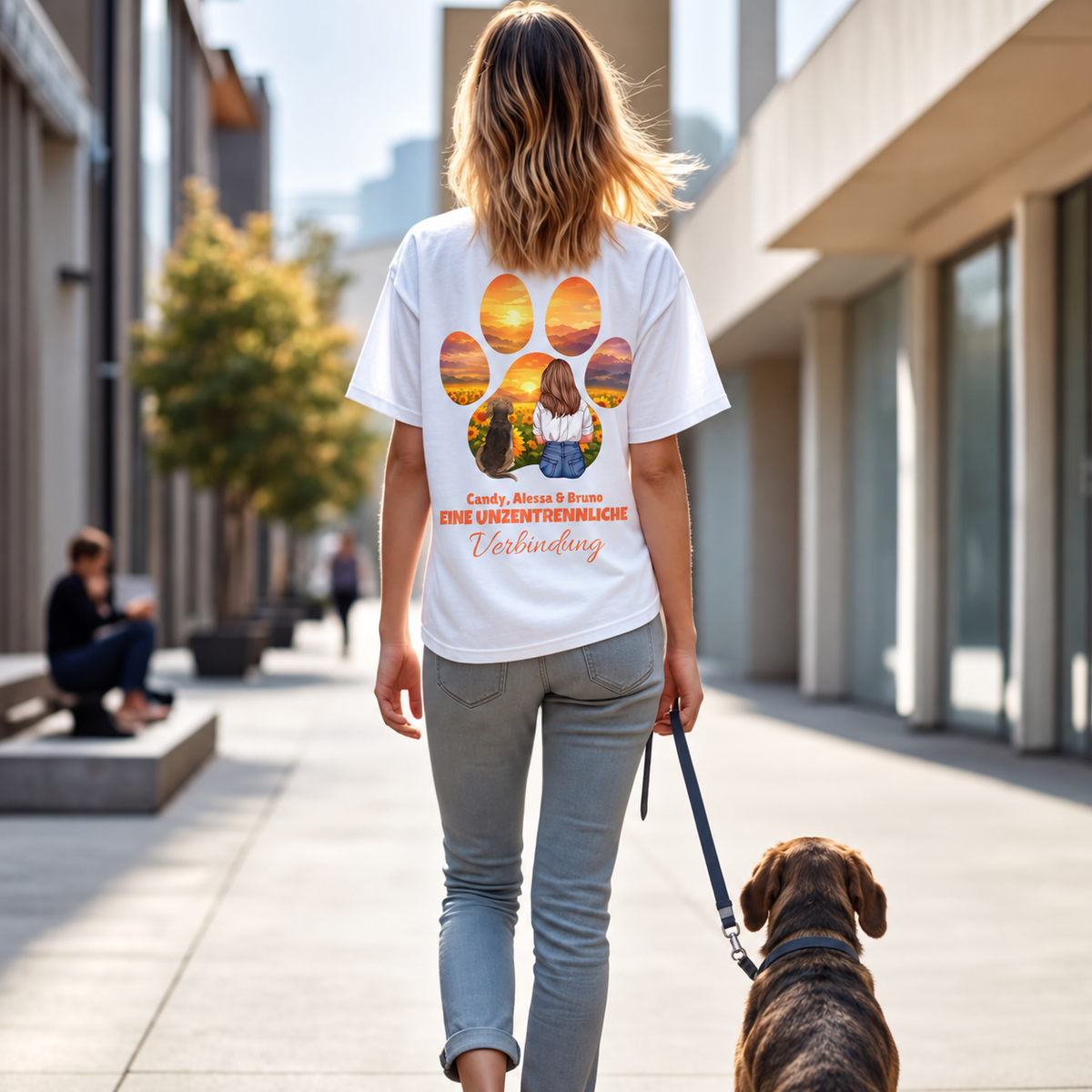 Camiseta blanca con diseño personalizado y frase, vista trasera de una mujer paseando un perro.