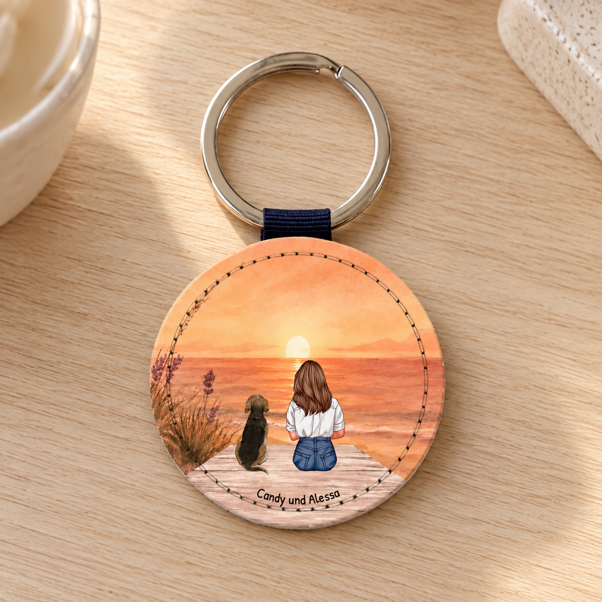 Llavero redondo personalizado con ilustración de una mujer y un perro al atardecer.