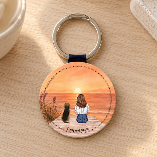 Llavero redondo personalizado con ilustración de una mujer y un perro al atardecer.