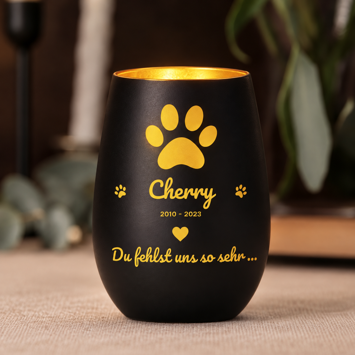 Luz conmemorativa negra con letras doradas y huellas, personalizada con nombre y año.