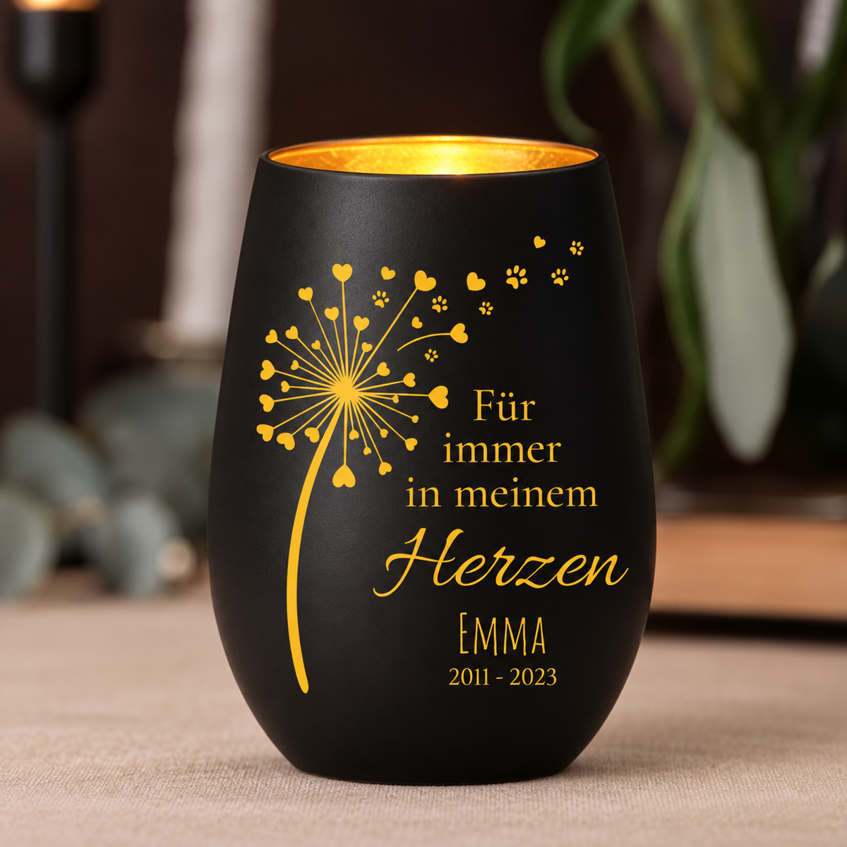 Vela conmemorativa negra con impresión dorada, personalizada con nombre y años, como luz de recuerdo.