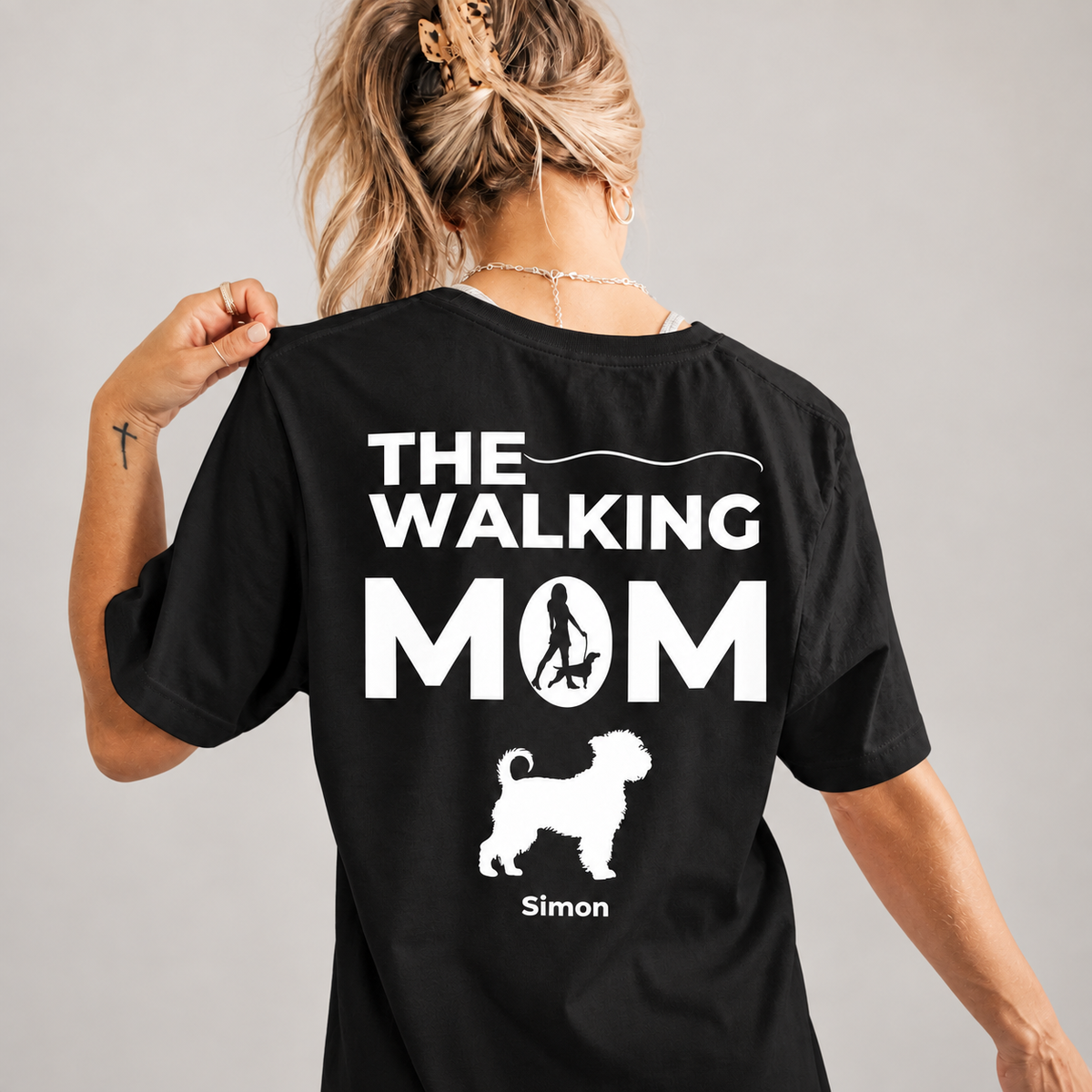 Camiseta negra con el texto "THE WALKING MOM" y silueta de perro en la espalda.