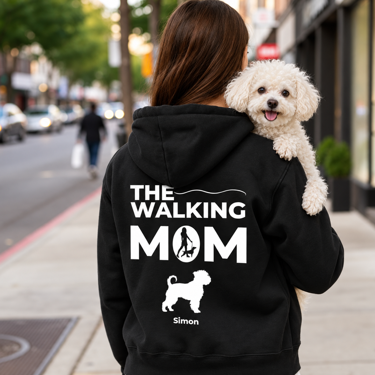 Sudadera con capucha negra con impresión personalizada "THE WALKING MOM" y motivo de perro. Persona con un perro en brazos.