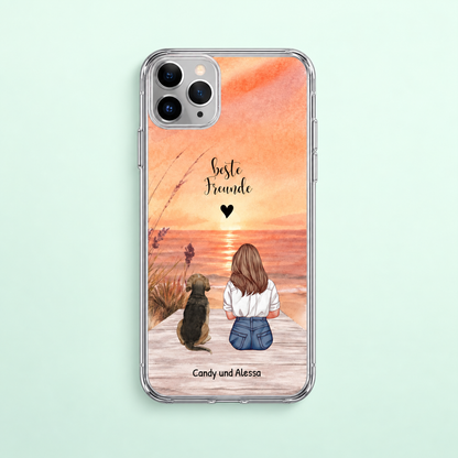 Funda de móvil transparente personalizada con ilustración de una niña y un perro en la playa al atardecer.