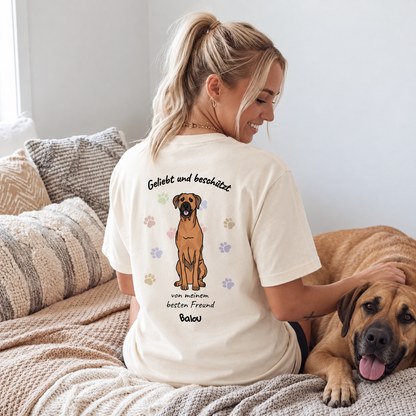 Camiseta beige con el texto "Geliebt und beschützt" y motivo de perro en la espalda.