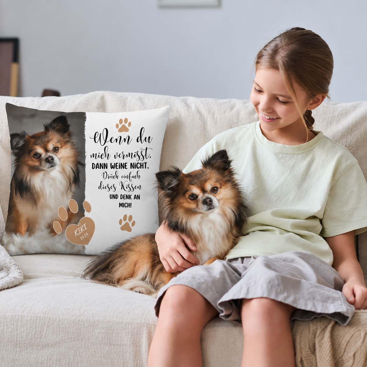 Cojín personalizado con foto de perro y texto en negro y beige, en un sofá con una niña y un perro.