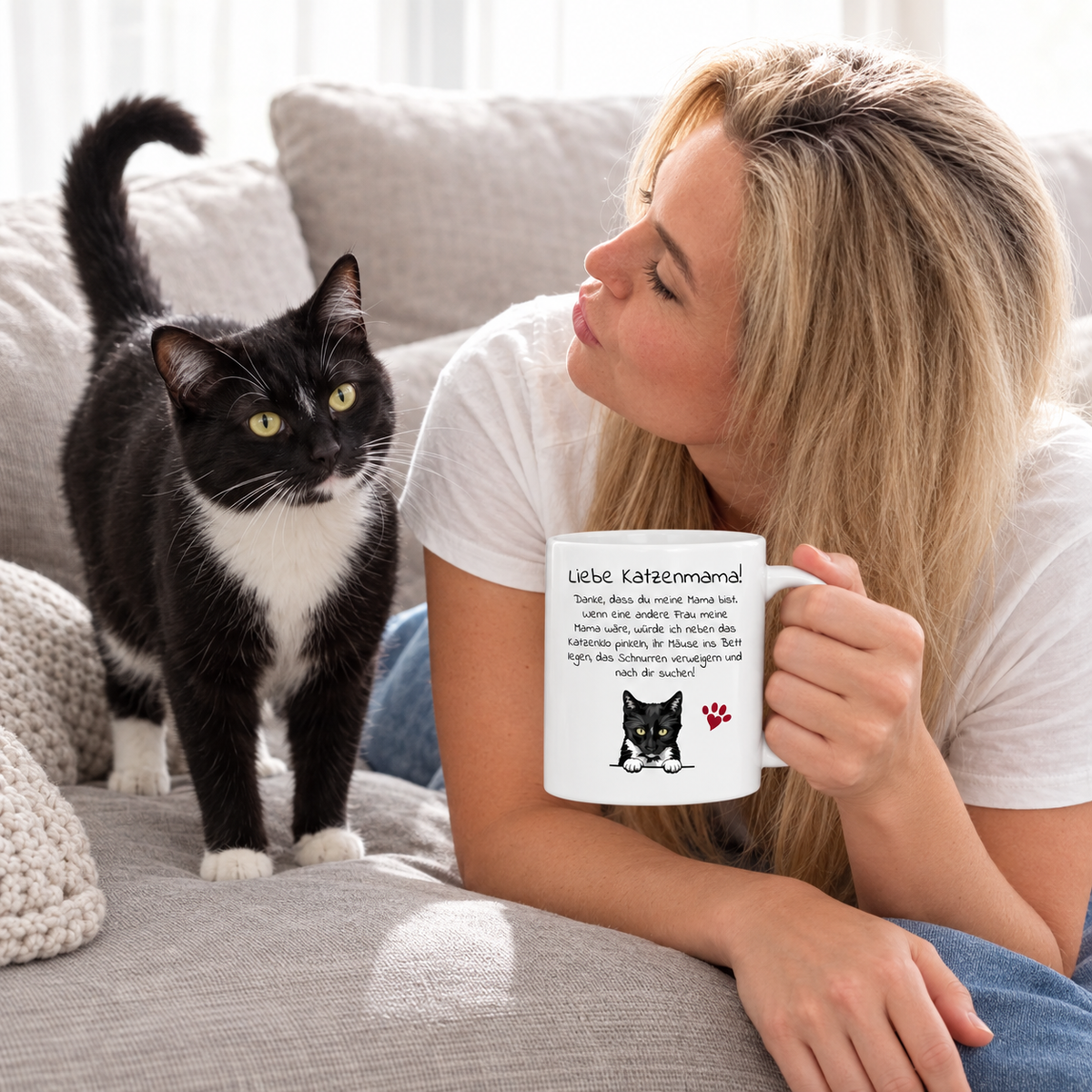 Persona bebiendo de una taza blanca con motivo de gato, gato negro en el suelo.