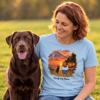 Camiseta azul con impresión gráfica de una mujer y su perro ante un paisaje de montaña.