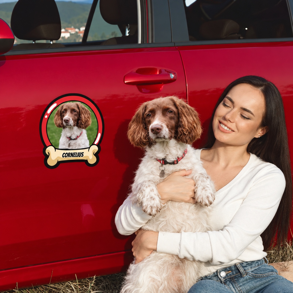 Pegatina de coche personalizada con foto de perro y nombre en un coche rojo, mujer con un perro en brazos.