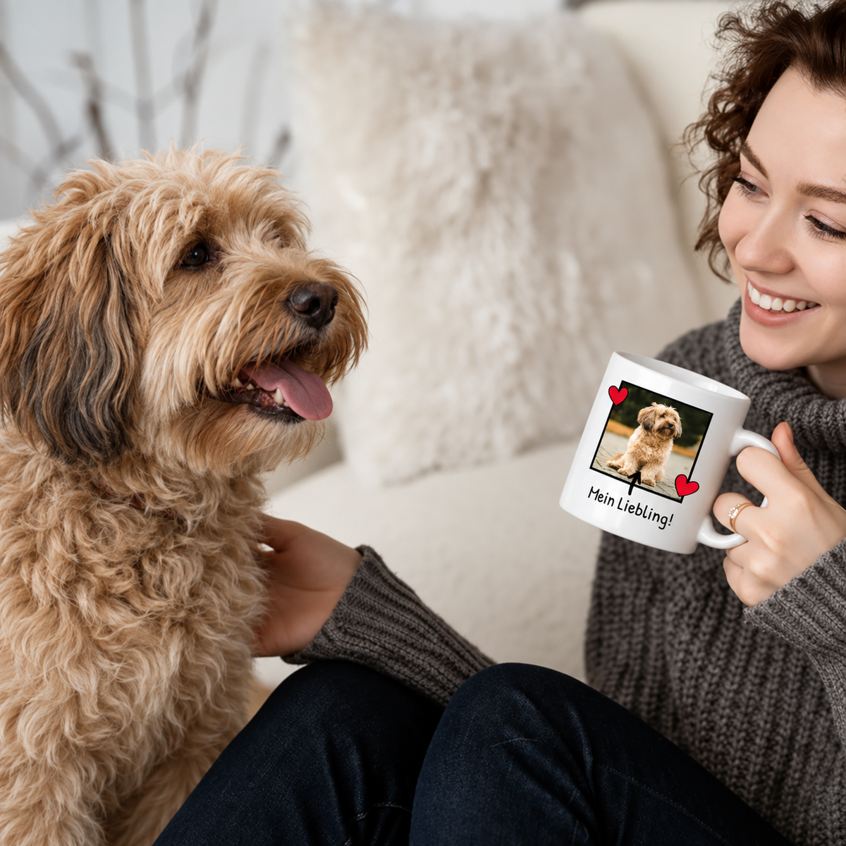 Persona bebiendo de una taza blanca con foto de perro y texto, sentada junto a un perro.