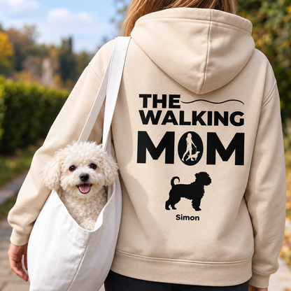 Sudadera con capucha beige con el texto "THE WALKING MOM" y motivo de perro, llevada por una persona con un perro.