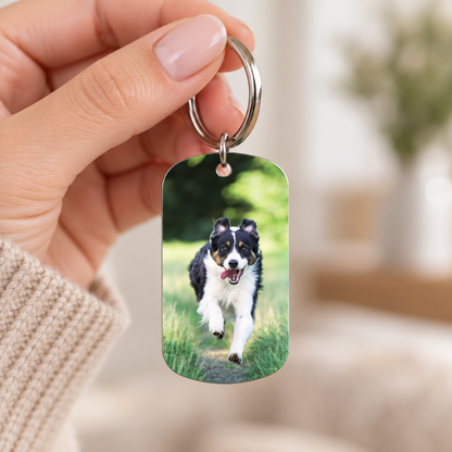 Llavero de metal personalizado con motivo de perro, sostenido en la mano.