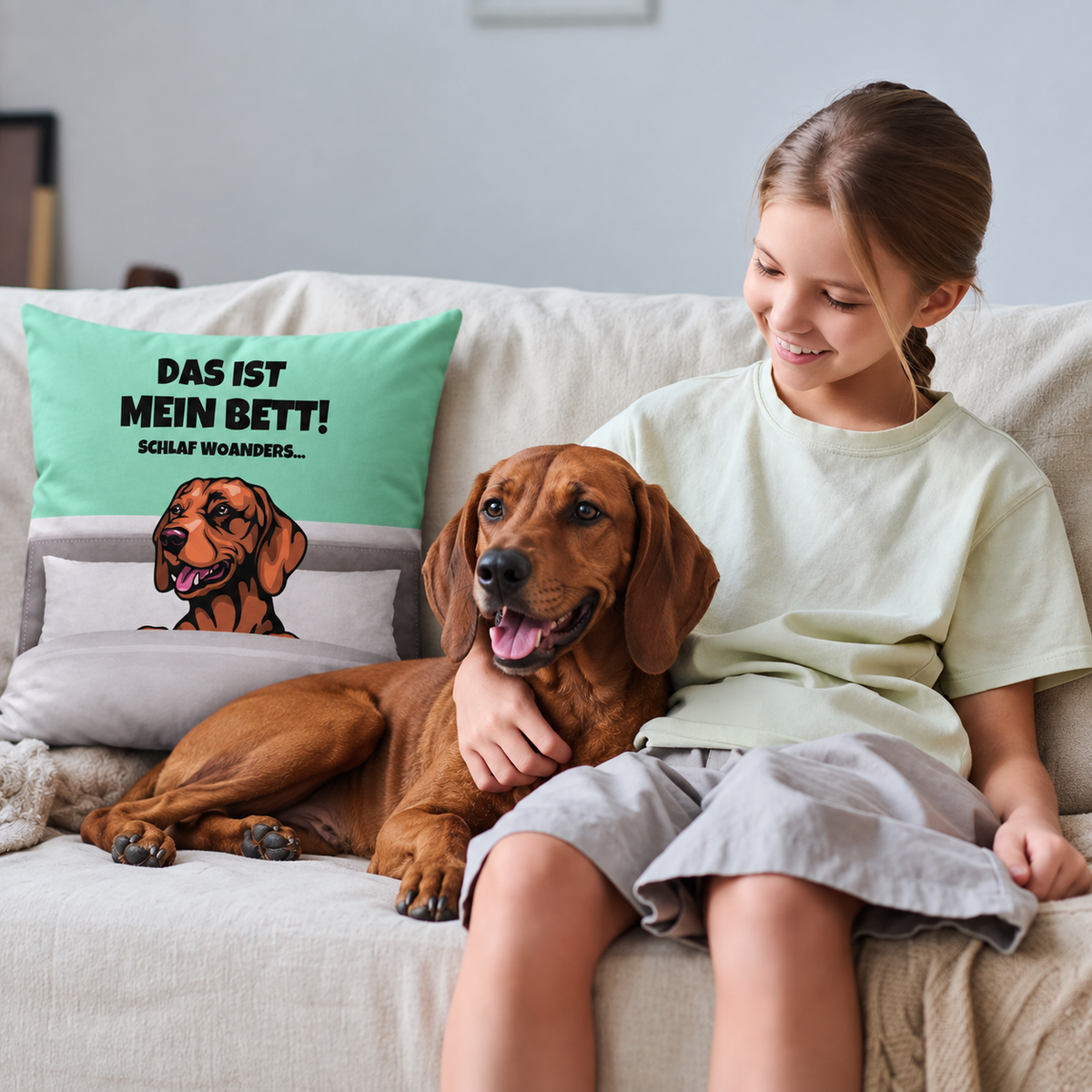 Cojín personalizado con motivo de perro en verde menta y gris, con una niña y su perro en el sofá.