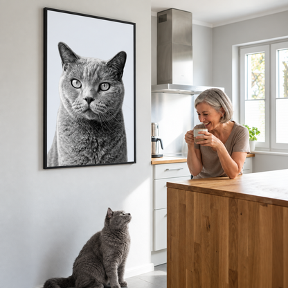 Persona sonriente mostrando un retrato personalizado de un gato gris en la pared.