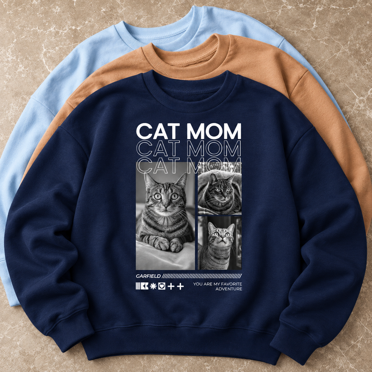Sudadera azul oscuro con motivos de gatos y el texto "CAT MOM" en mayúsculas.