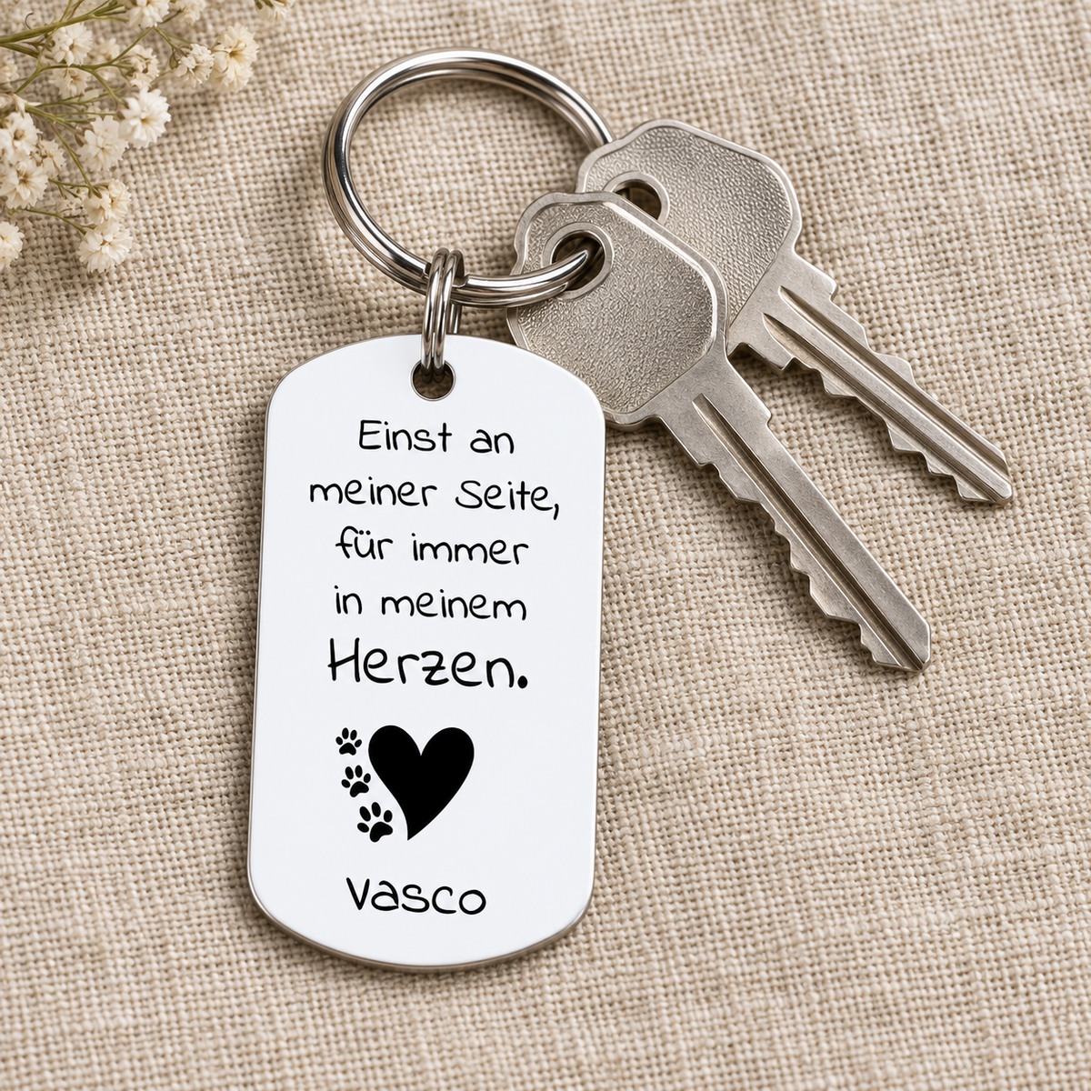 Llavero de metal personalizado con superficie blanca y letras negras.