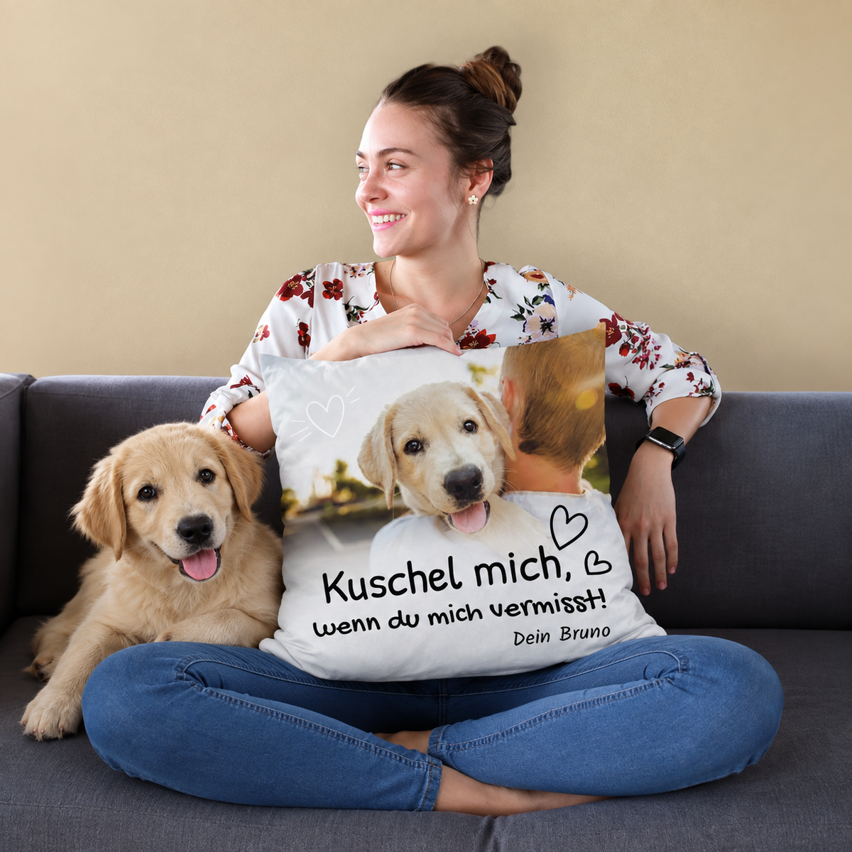 Cojín con diseño personalizado y el texto "Kuschel mich, wenn du mich vermisst!", perro y mujer en un sofá.