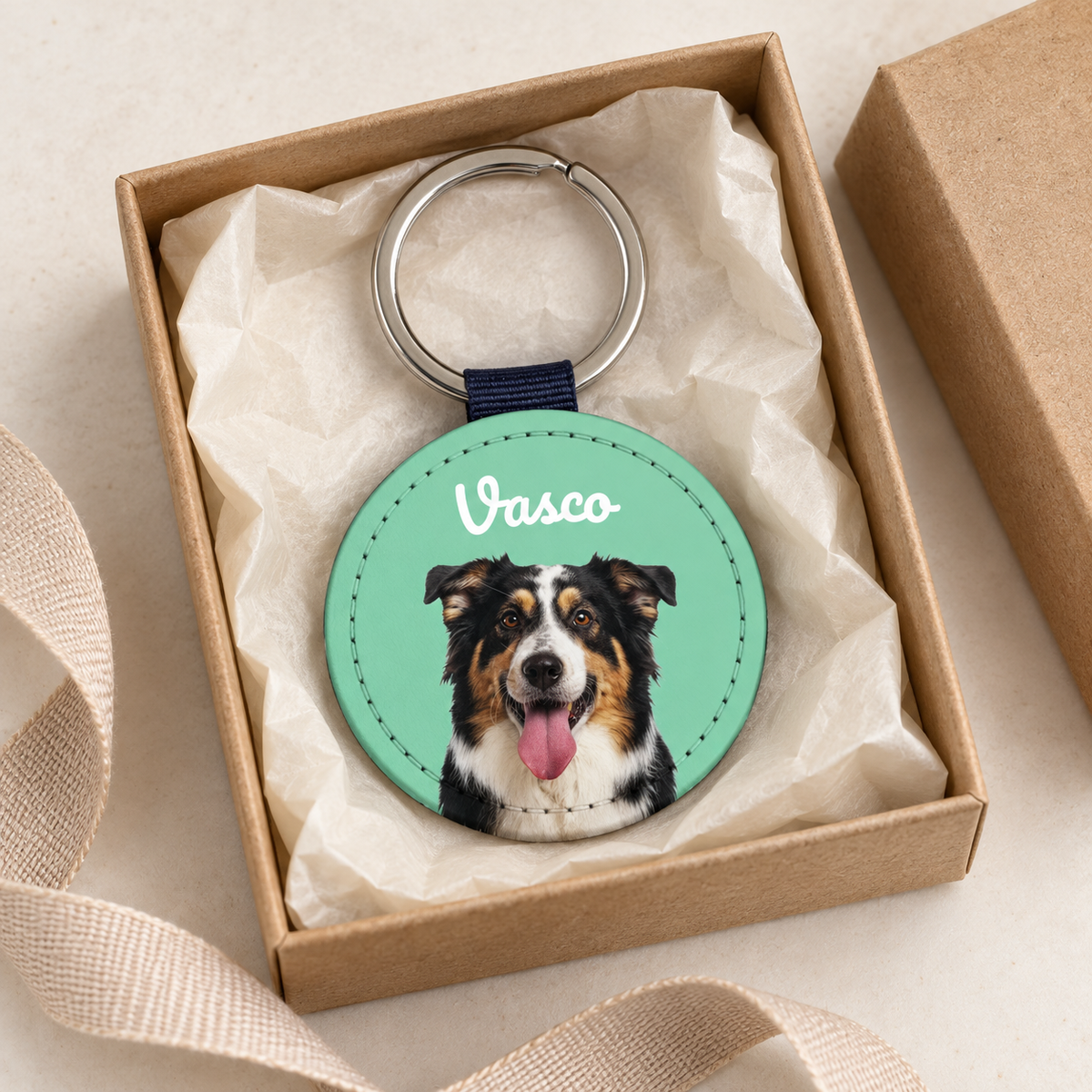 Llavero personalizado con retrato de perro sobre fondo verde, en una caja de regalo.
