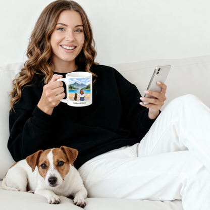 Persona sosteniendo una taza personalizada con paisaje, un perro tumbado a su lado en el sofá.