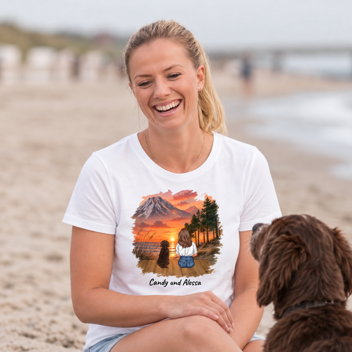 Camiseta blanca con impresión personalizada de un paisaje con perro, la mujer ríe en la playa.
