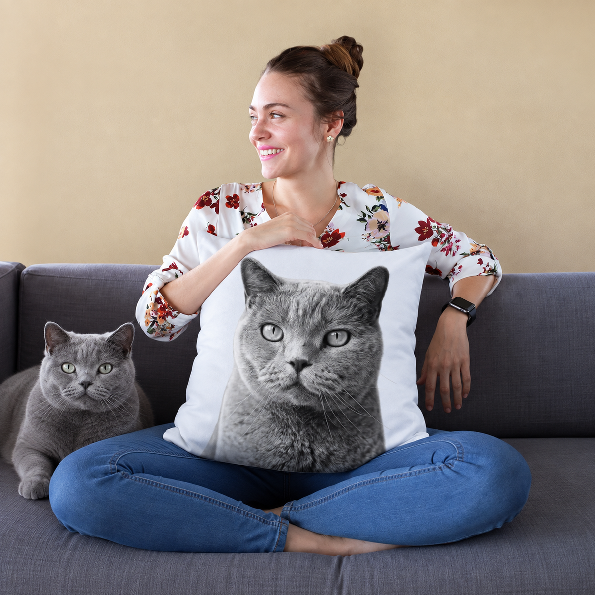 Cojín con retrato de gato en blanco y negro, persona sentada en un sofá sosteniendo el cojín.
