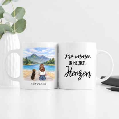Taza blanca personalizada con ilustración de una mujer y un perro junto a un lago y el texto "Für immer in meinem Herzen".