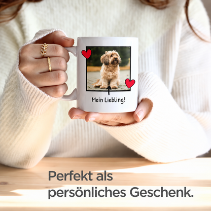 Persona sosteniendo una taza blanca con foto de perro y texto, chaqueta de punto cálida.