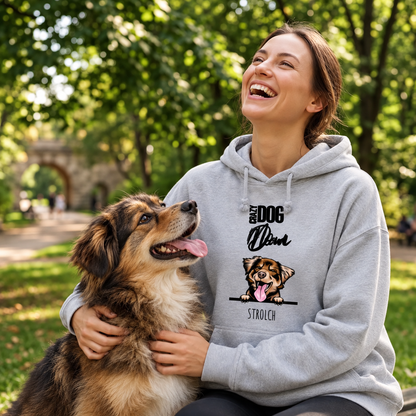 Sudadera con capucha gris con motivo de perro, llevada por una mujer que ríe y juega con su perro en el parque.
