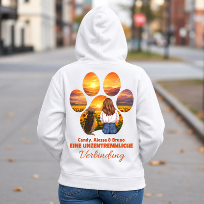 Sudadera con capucha blanca con una persona y un perro al atardecer, texto: "Eine unzertrennliche Verbindung".