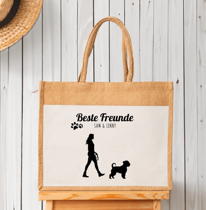 Bolsa de compras personalizada de yute con siluetas negras de persona y perro. Inscripción “Mejores amigos”.