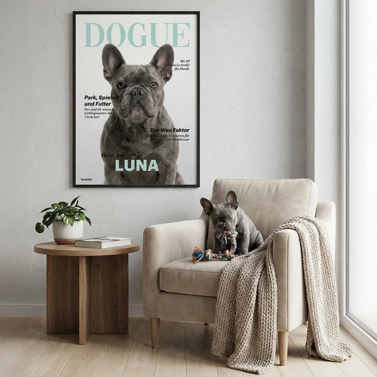 Decoración de pared personalizada con póster de perro, sofá marrón, maceta y juguetes sobre una mesa.