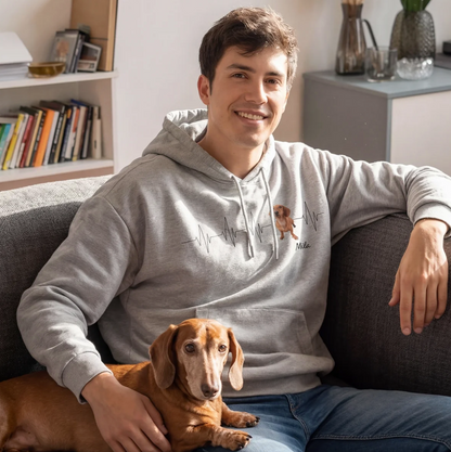 Sudadera con capucha gris con motivo de latido y foto de perro, sentado en un sofá con un teckel en brazos.