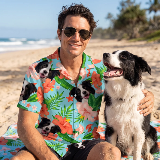 Hombre con gafas de sol y camisa hawaiana personalizada con motivos de perros, sentado en la playa junto a un perro.