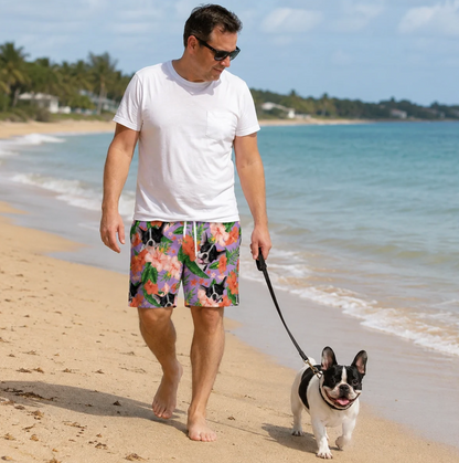 Hombre con bañador personalizado de flores y animales de colores, paseando descalzo por la playa.