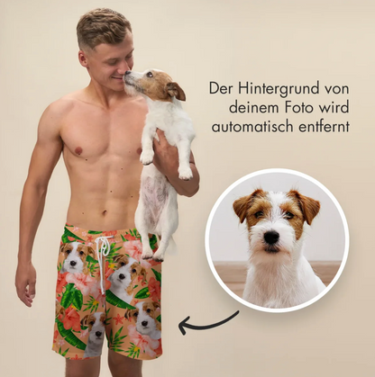 Hombre con bañador corto estampado con perros y flores, sosteniendo un perro en brazos.