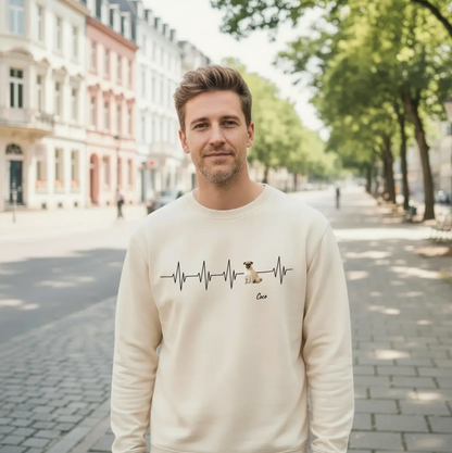 Sudadera beige con motivo de latido y perro, llevada por un hombre en un paisaje urbano.