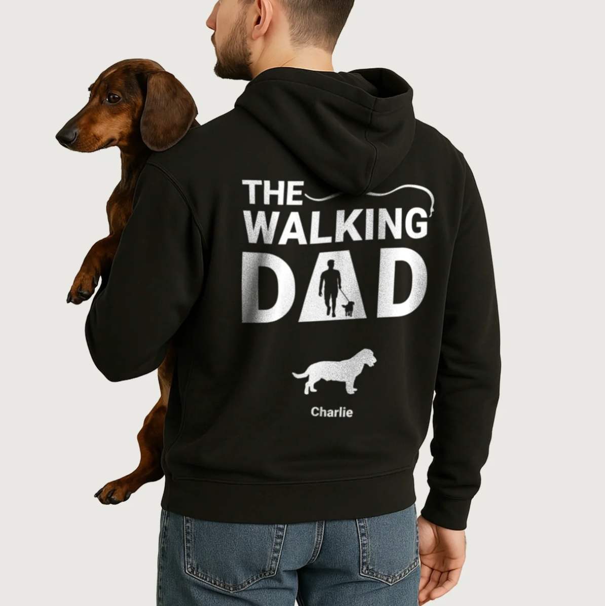 Sudadera con capucha negra con impresión personalizada "The Walking Dad" y motivos de perros. La lleva un hombre con un perro.