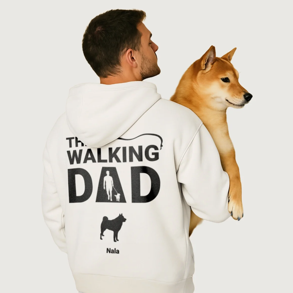 Sudadera con capucha blanca con "THE WALKING DAD" impreso en la espalda y motivo de perro, modelo con un perro en brazos.