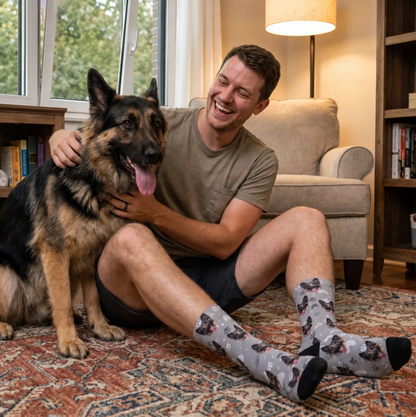Calcetines personalizados grises con motivo de perro y detalles negros y rosas, llevados por un hombre con un perro.