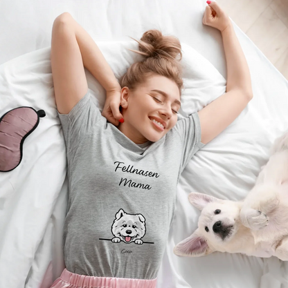 Camiseta gris con el texto "Fellnasen Mama" y motivo de perro, llevada por una mujer sonriente en la cama.